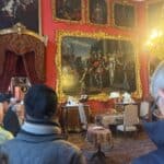 Na ścianach wnętrza muzealnego wiszą portrety rodzinne w złotych ramach.