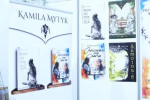 Stoisko autorskie pisarki Kamili Mytyk z banerem i książkami, w tym „Mam na imię Ola”, „Owocowa czy czarna” i „Samotna 6”.