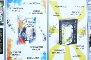 Plansza informacyjna zawiera hasła „zdrowie psychiczne”, „siła kobiet” i „narcyzm” oraz okładki książek Kamili Mytyk „Owocowa czy czarna” i „Samotna 6”.