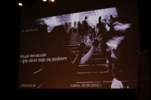 Slajd z tytułem „Visual Vernacular – gdy obraz staje się językiem”. Po prawej stronie znajduje się czarno-białe zdjęcie grupy ludzi na schodach. W lewym dolnym rogu widnieje nazwisko Edyta Kozub, a w prawym data i miejsce: Lublin, 28.09.2026 r.